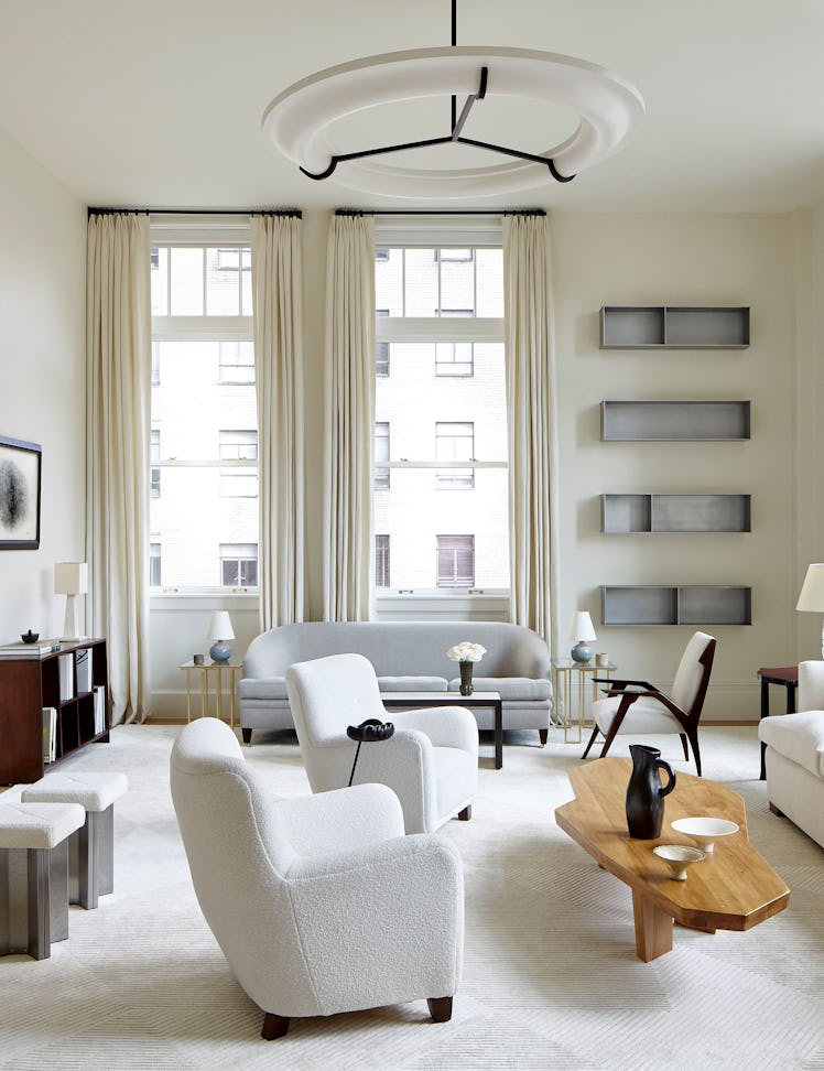 An elegant living room decorated in shades of white with contemporary art on display
