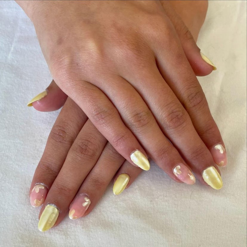 Yellow chrome nails with flower petal details are on-trend for spring 2024.