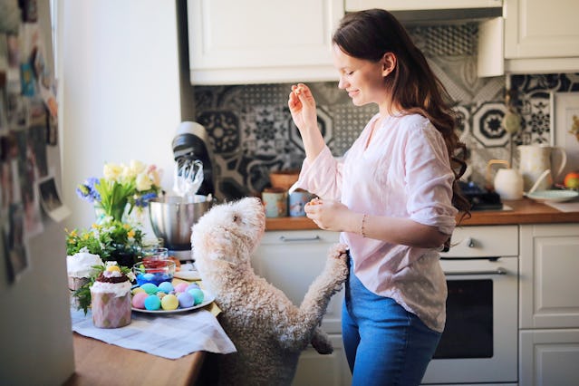 A woman gives her dog a treat on Easter.