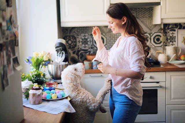 A woman gives her dog a treat on Easter.