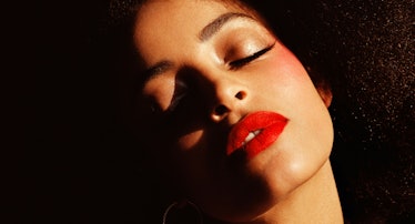 a woman wearing red lipstick with her eyes closed