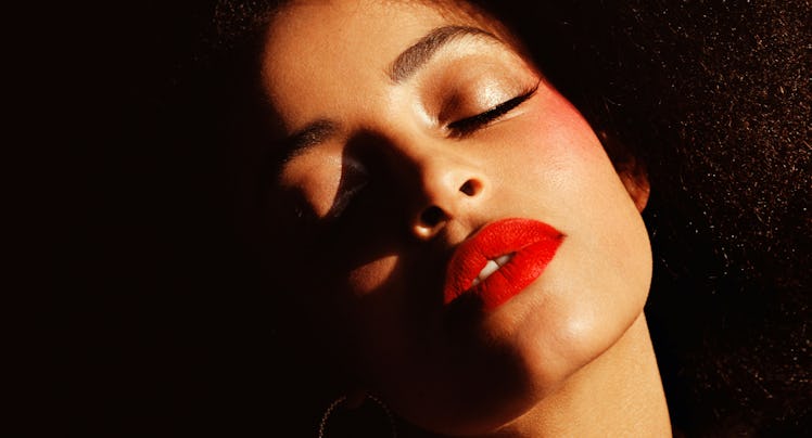 a woman wearing red lipstick with her eyes closed