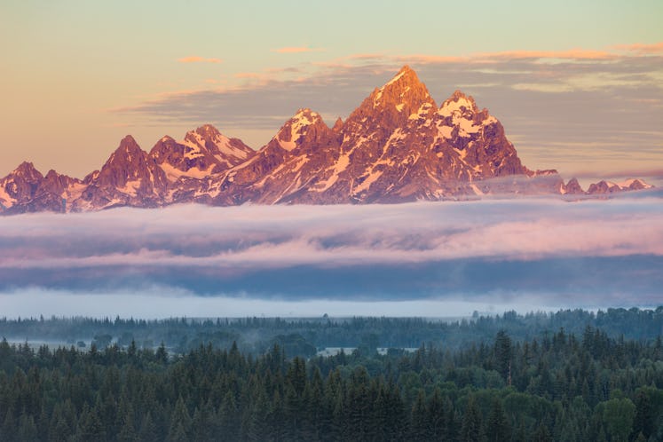 Grand Teton and the Teton Range with low clouds at sunrise in Grand Teton National Park.