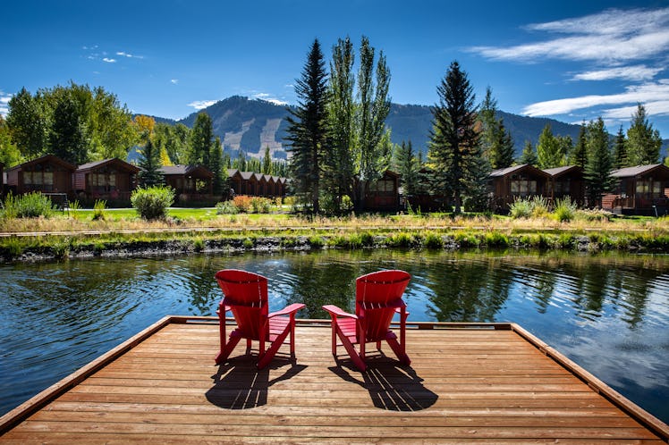 Adirondack chairs are situated along Flat Creek at the Rustic Inn near downtown Jackson and across t...