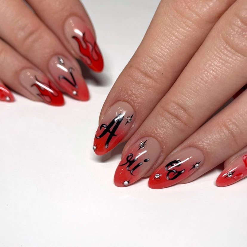 Airbrushed art on red nails are trending for Aries season 2024.