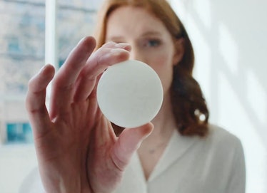 Une femme tenant un disque blanc compatible IA devant la caméra.