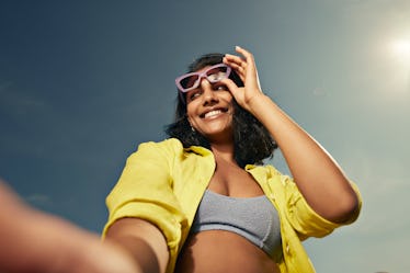Woman holding sunglasses up on her face during the 2024 total solar eclipse.