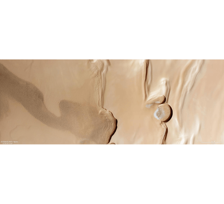 A rectangular slice of tan-coloured terrain shows a number of features on Mars: a rippling swathe of...