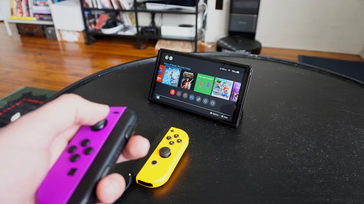 Using a Joy-Con controller in front of a Nintendo Switch on a coffee table.