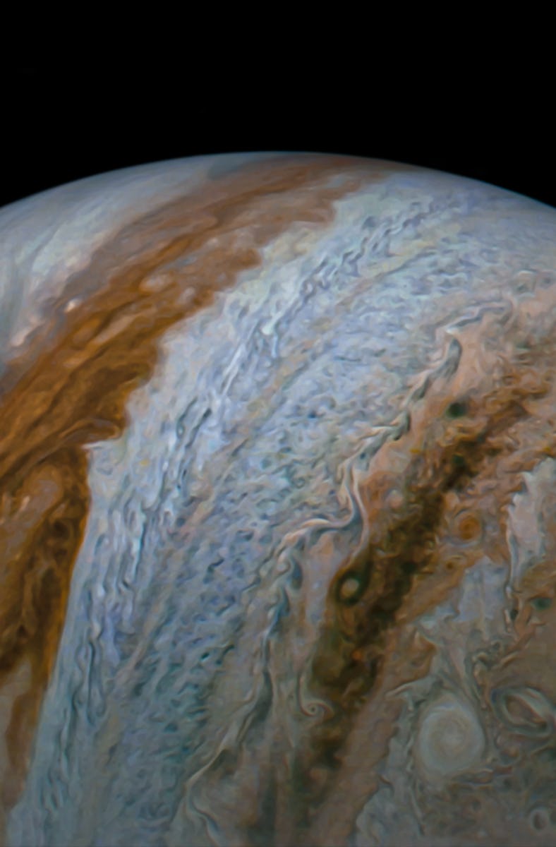 Jupiter resembles a marble. Thick bands of clouds wrap around the planet, whose equator bisects the ...