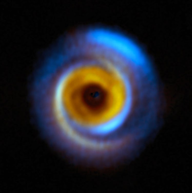 A sphere with a gap in the middle is a protoplanetary disk. Vivid color in the center represents the...