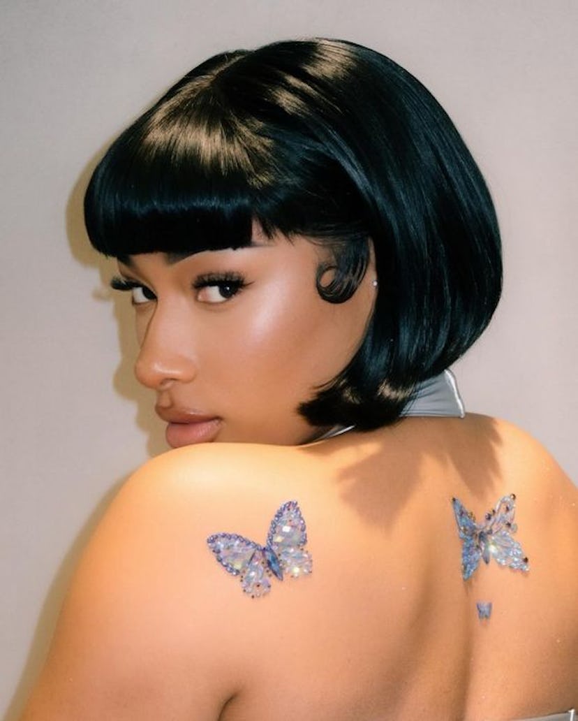 Megan Thee Stallion wears temporary bedazzled butterfly tattoos in Tokyo, Japan.