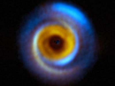 A sphere with a gap in the middle is a protoplanetary disk. Vivid color in the center represents the...