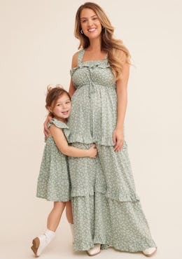 A woman wearing a sage floral Easter 2024 dress from Tullabee, pictured with a young girl in a match...