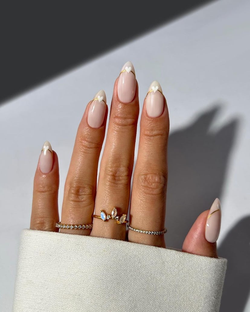 Invisible French tip nails with white love hearts are on-trend.
