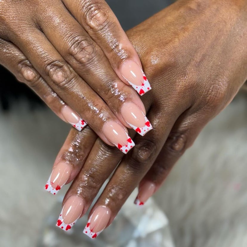 French tip nails topped with red hearts are on-trend.
