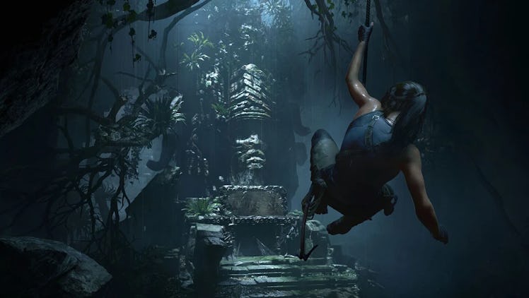 Lara Croft swings across a chasm.