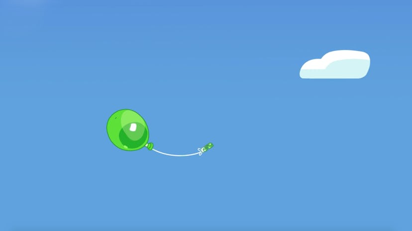 A green balloon floats through a clear blue sky.
