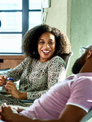 A man and a woman flirt while talking at work.