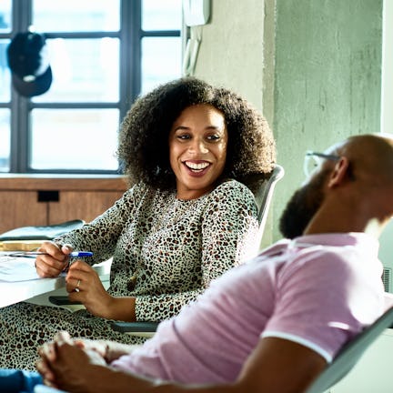 A man and a woman flirt while talking at work.