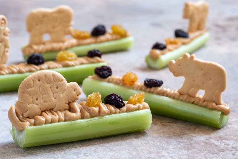 Ants on a wood snack with animal crackers, in a list of Earth Day snacks and snack ideas.