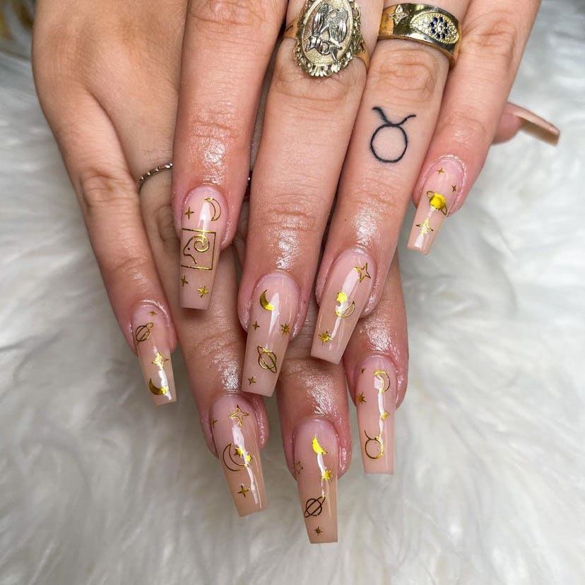 Try neutral nails with gilded celestial nail stamps for Taurus season 2024.