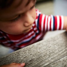 A mosquito lands on a little boy's arm.