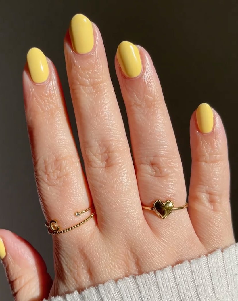 Warm yellow nail polish in on-trend for summer 2024.