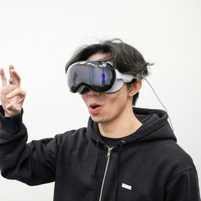 Inverse Deputy Editor of Tech wearing the Apple Vision Pro spatial computer headset and using a hand...