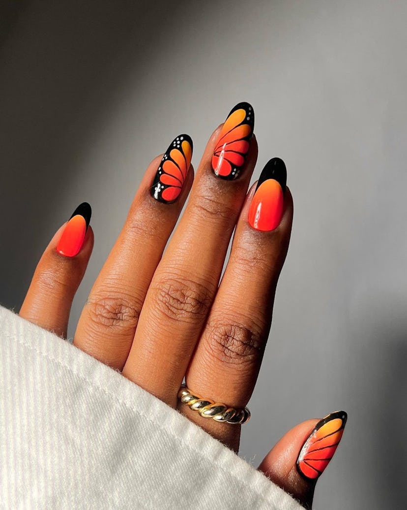 Neon orange monarch butterfly nail designs are on-trend.