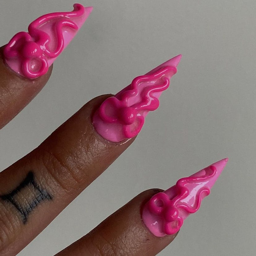 3D hot pink ribbons on nails are on-trend.