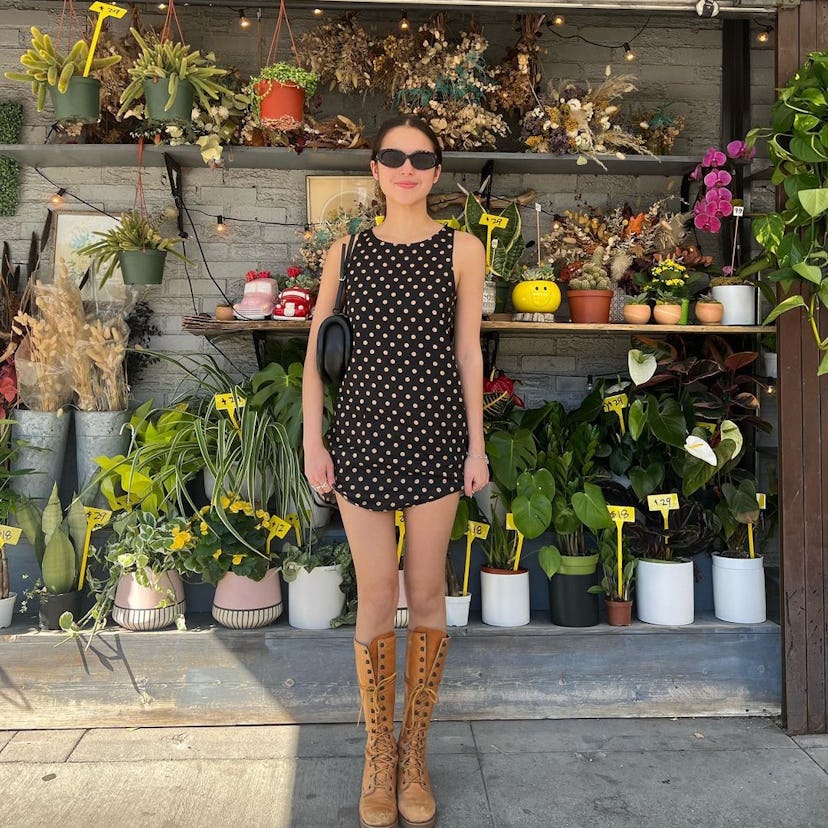 Olivia Rodrigo wears a polka dot dress and lace up boots.