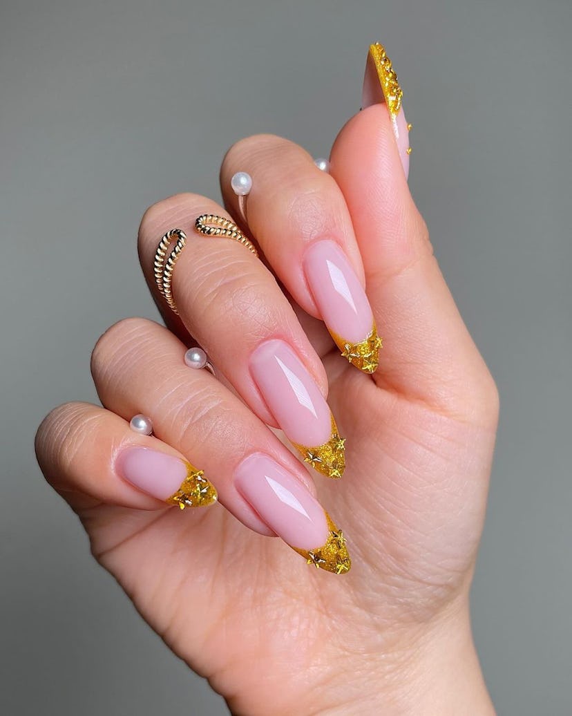 Bedazzled yellow-gold French tip nails are on-trend.