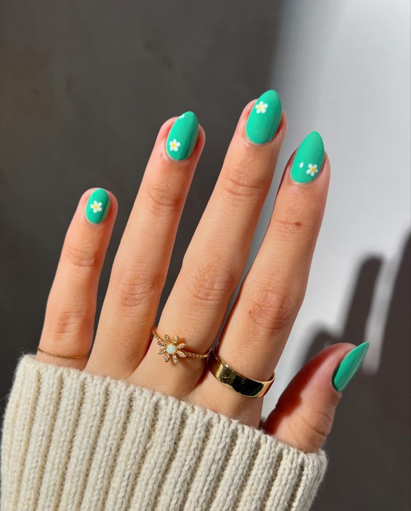 Bright green nails with daisies are on-trend.