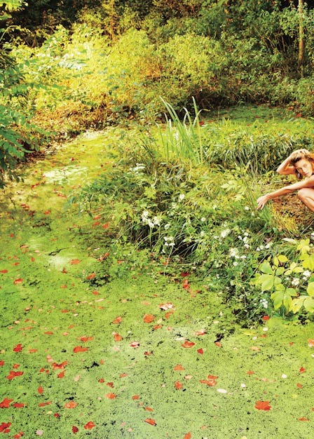 A photograph by Ryan McGinley, styled by Edward Enninful in W July 2013. A model sits in a garden