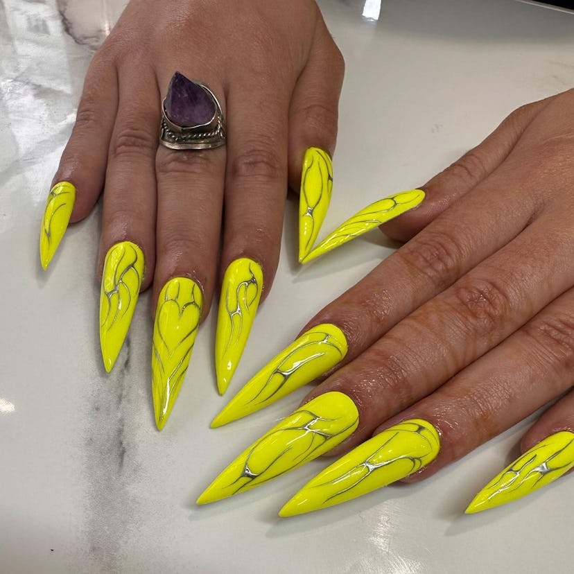 Neon yellow nails with silver tribal designs are on-trend.