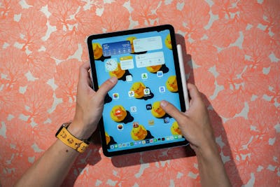 Inverse deputy tech editor Raymond Wong holding an fifth-generation iPad Air and Apple Pencil