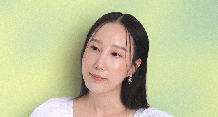 Erica Choi soft smiles wearing a white poofy sleeved dress