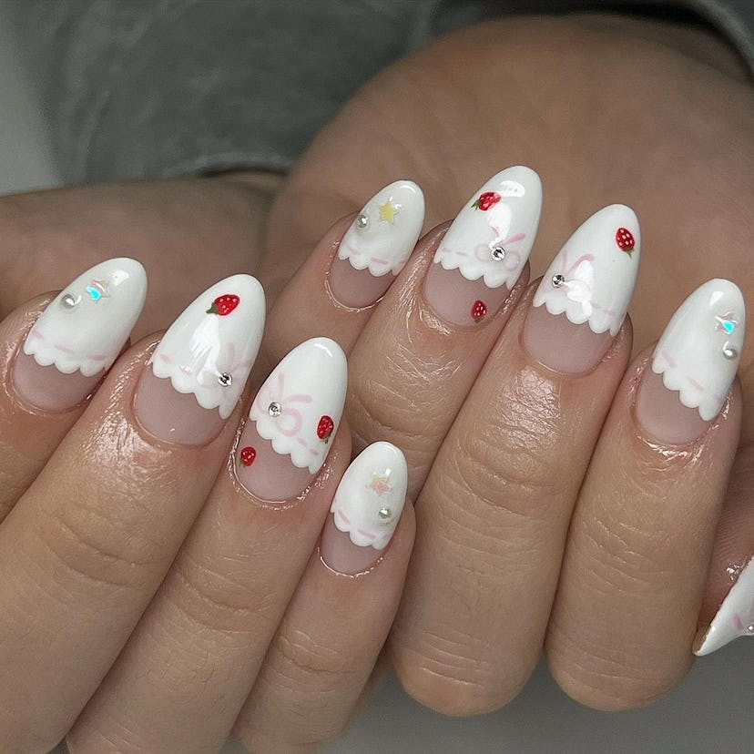 Try coquette French tip nails with micro strawberry art.