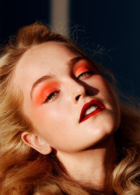 a photo of a blonde woman with orange eyeshadow and red lipstick