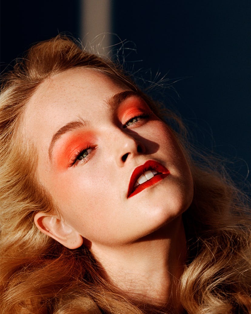 a photo of a blonde woman with orange eyeshadow and red lipstick