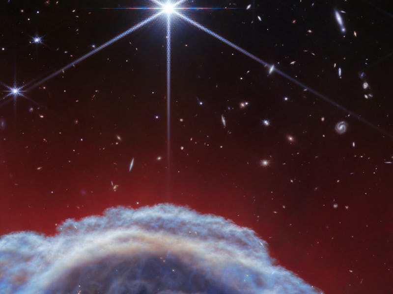 A vibrant space scene with a bright star shining above a cloud-like celestial body against a backdro...