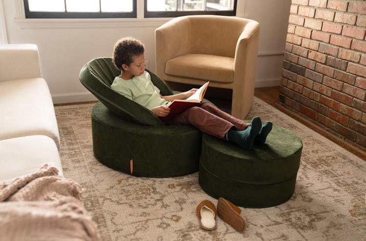 Child sitting in Nugget Chunk play ottoman, arranged as a chair.