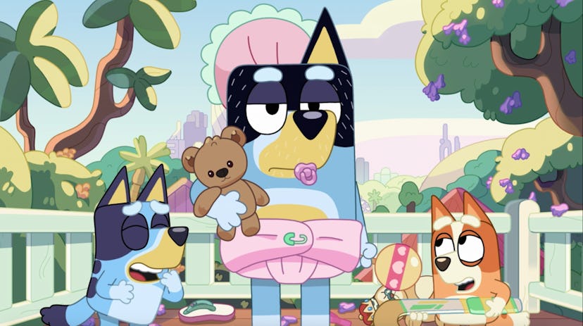 Bandit is dressed as a baby girl as Bingo and Bluey laugh.