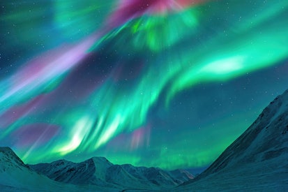 Aurora Borealis (Northern Lights) exploding over the Alaskan peaks near Atigun Pass along the Dalton...