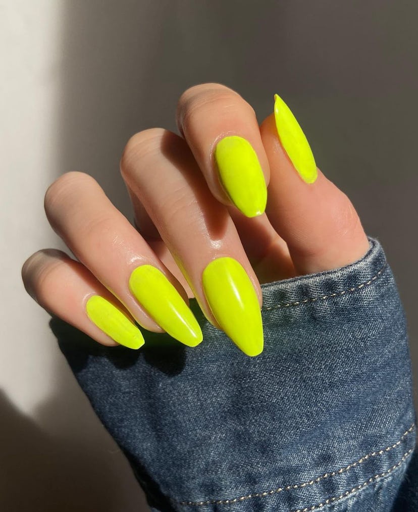 Neon yellow nail polish is on-trend for summer 2024.