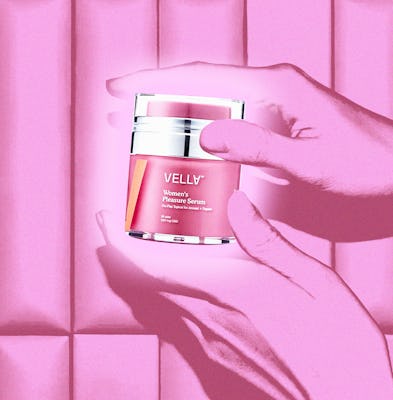 Hand holding a jar of VellV Women's Pleasure Serum against a pink tiled wall.