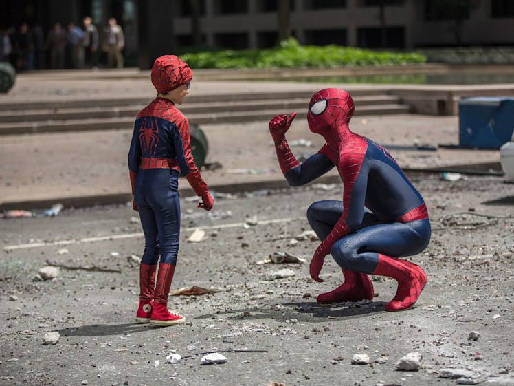 Andrew Garfield kneels in front of a young Spider-Man fan in 'The Amazing Spider-Man 2'