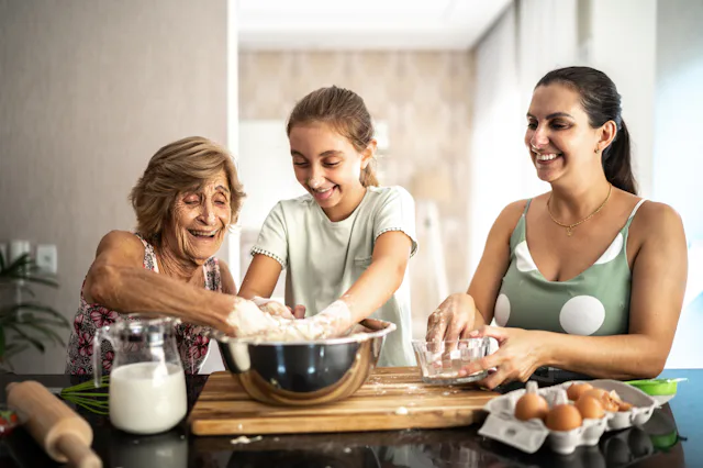 A grandmother, granddaughter, and mother bake together.
