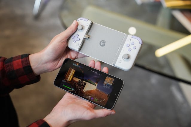 Inverse editor James Pero holding a GameSir X2s mobile gaming controller next to a Nothing Phone 2.